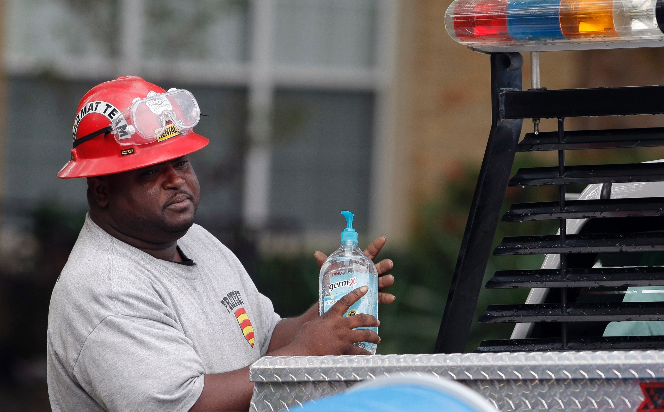 PHOTO: A Protect Environmental Services employee sanitizes his hands outside the apartment of a healthcare worker who tested positive for Ebola, Oct. 13, 2014, in Dallas.