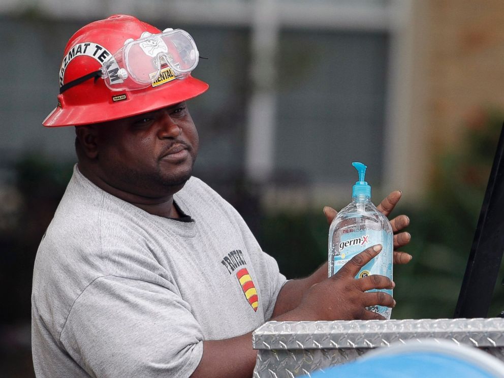PHOTO: A Protect Environmental Services employee sanitizes his hands outside the apartment of a healthcare worker who tested positive for Ebola, Oct. 13, 2014, in Dallas.