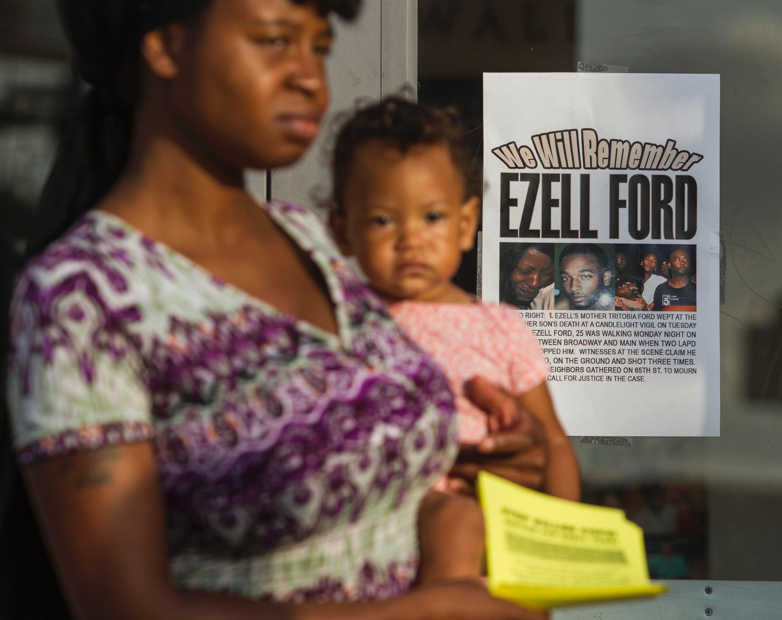 PHOTO: In this Aug. 19, 2014, file photo, Keyanna Celina holds her daughter Massiah in front of a poster reading, "We Will Remember Ezell Ford" at the Paradise Baptist Church in Los Angeles.