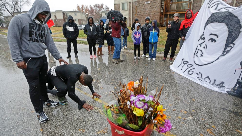 PHOTO: Ray Mills, left, and Londrelle Hall pause before a memorial in the middle of a street Sunday, Nov. 23, 2014, more than three months after a black 18-year-old was shot and killed there by a white policeman in Ferguson, Mo.