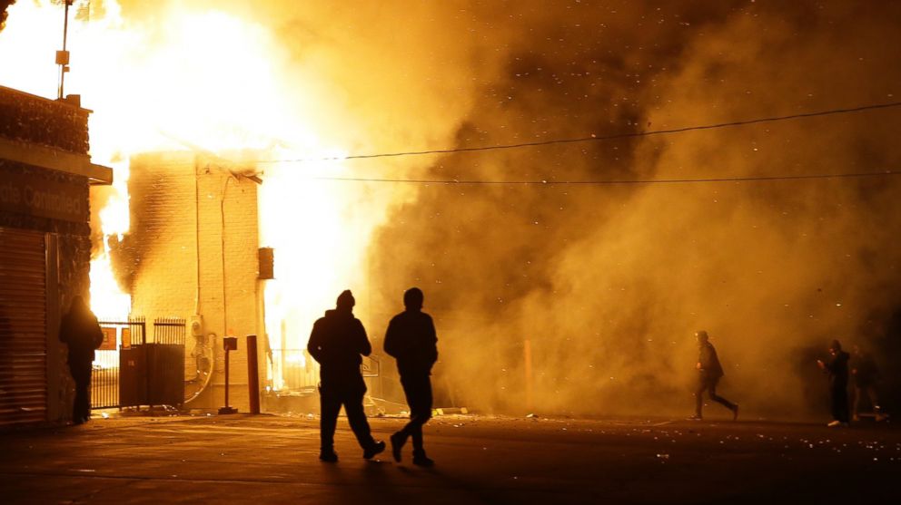People walk away from a storage facility on fire after the announcement of the grand jury decision, Nov. 24, 2014, in Ferguson, Mo. 