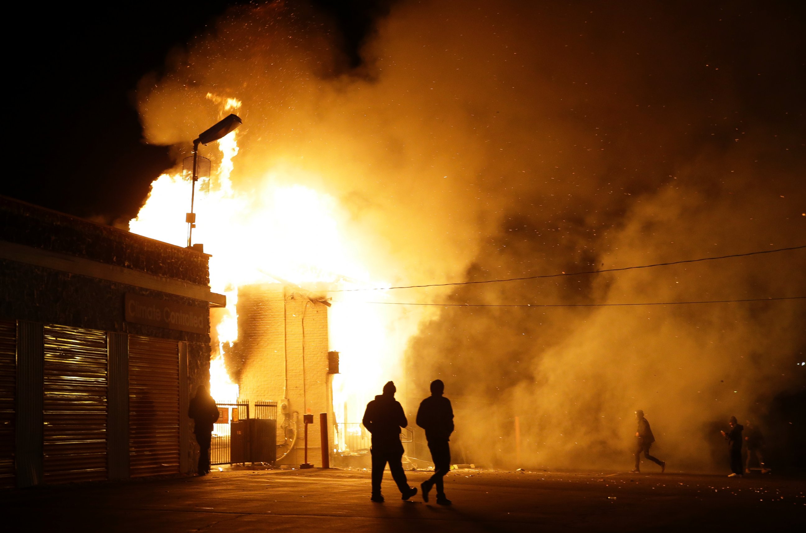 PHOTO: People walk away from a storage facility on fire after the announcement of the grand jury decision, Nov. 24, 2014, in Ferguson, Mo. 