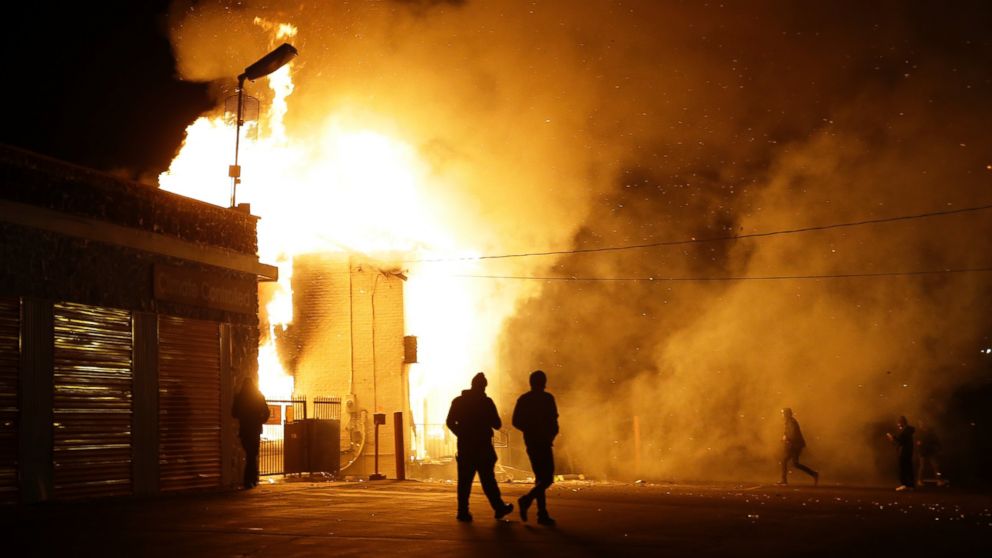 PHOTO: People walk away from a storage facility on fire after the announcement of the grand jury decision, Nov. 24, 2014, in Ferguson, Mo. 