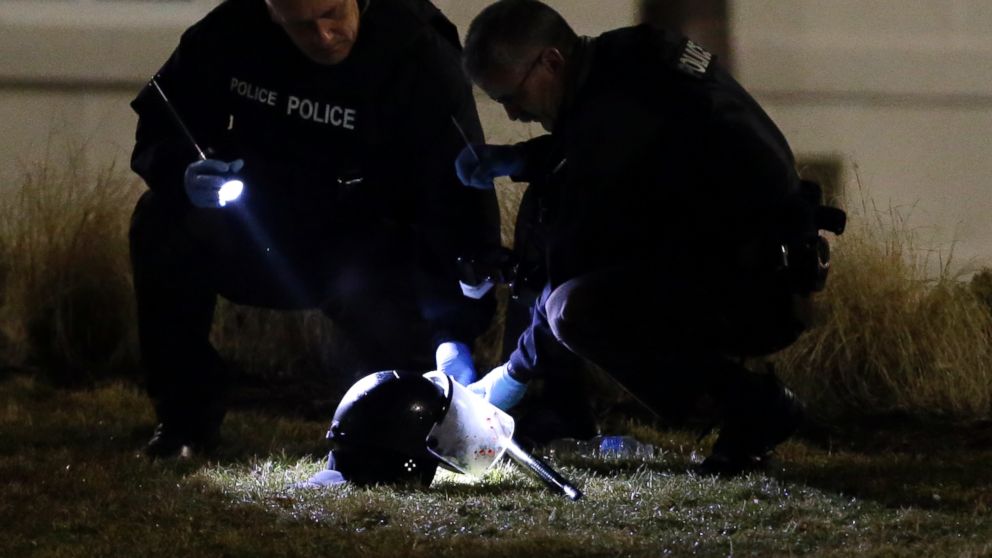 PHOTO: Police shine a light on a helmet as they investigate the scene where two police officers were shot outside the Ferguson Police Department, March 12, 2015, in Ferguson, Mo.