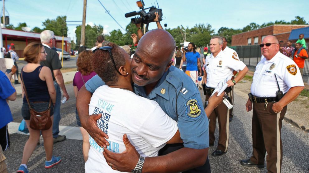 PHOTO: Capt. Ronald Johnson of the Missouri Highway Patrol hugs Angela Whitman, of Berkeley, Mo., on West Florissant Avenue in Ferguson, Mo., on Aug. 14, 2014. 