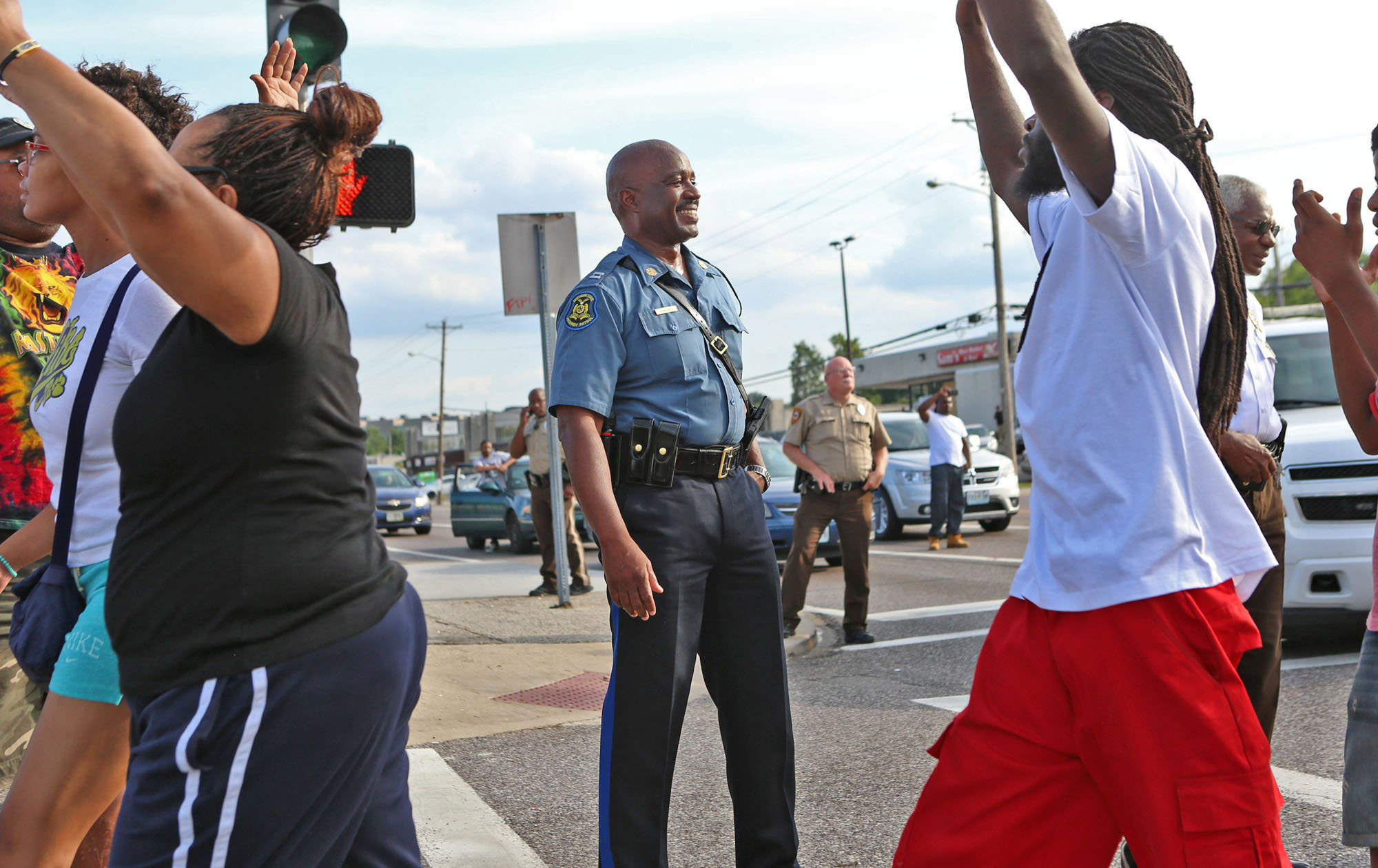 PHOTO: Capt. Ronald Johnson of the Missouri Highway Patrol smiles at demonstrators march along West Florissant Avenue in Ferguson, Mo., on Aug. 14, 2014.