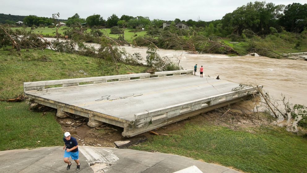 PHOTO: Dustin McClintock, of Wimberley,, Brandon Bankston, of Blanco, Hesston Krause, of Smithson Valley, look at the Fischer Store Road bridge over the Blanco River near Wimberley, Texas, which was destroyed in a flood on Sunday May 24, 2015.