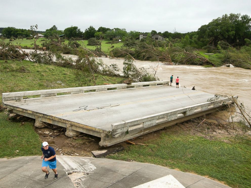 PHOTO: Dustin McClintock, of Wimberley,, Brandon Bankston, of Blanco, Hesston Krause, of Smithson Valley, look at the Fischer Store Road bridge over the Blanco River near Wimberley, Texas, which was destroyed in a flood on Sunday May 24, 2015.