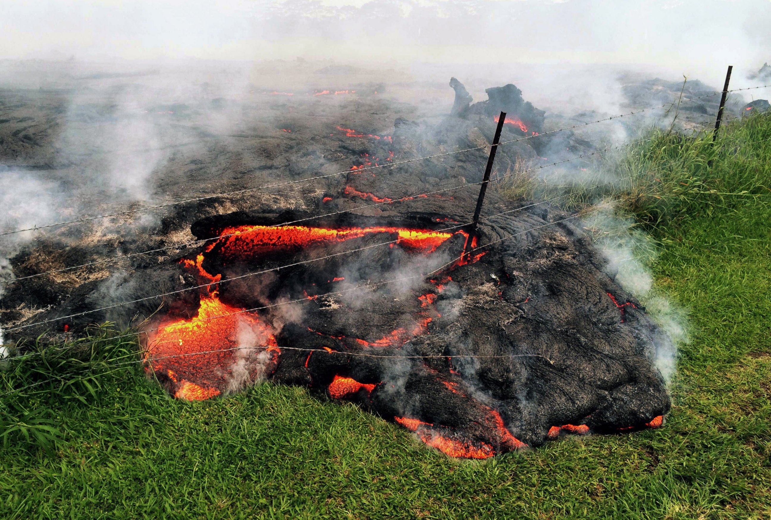 PHOTO: Lava flow advances across the pasture between the Pahoa cemetery and Apaa Street, engulfing a barbed wire fence, near the town of Pahoa on the Big Island of Hawaii, Oct. 25, 2014.