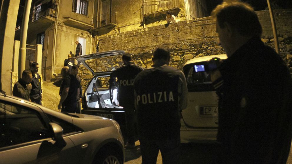 Police officers stand outside a suspect's house during an operation conducted with U.S. FBI agents, in Sinopoli, southern Italy, early Thursday morning, May 7, 2015. Italian police said that in operations conducted with U.S. FBI agents they have dismantled a major drug trafficking ring whose base was a restaurant-pizzeria in New York City. At least 15 suspects have been detained by early Thursday, including three in the United States connected with the eatery in the city's Queens borough. 