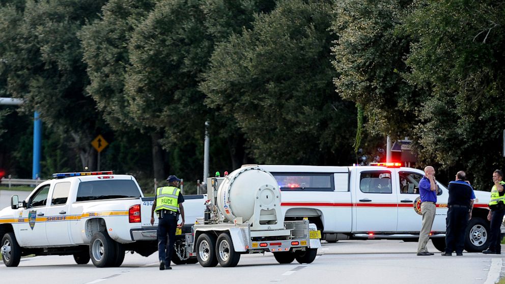 Police block the road to the Jacksonville International Airport terminal as the bomb disposal unit drives by on the right on Oct. 1, 2013, in Jacksonville, Fla. The airport was evacuated after authorities found two suspicious packages. 