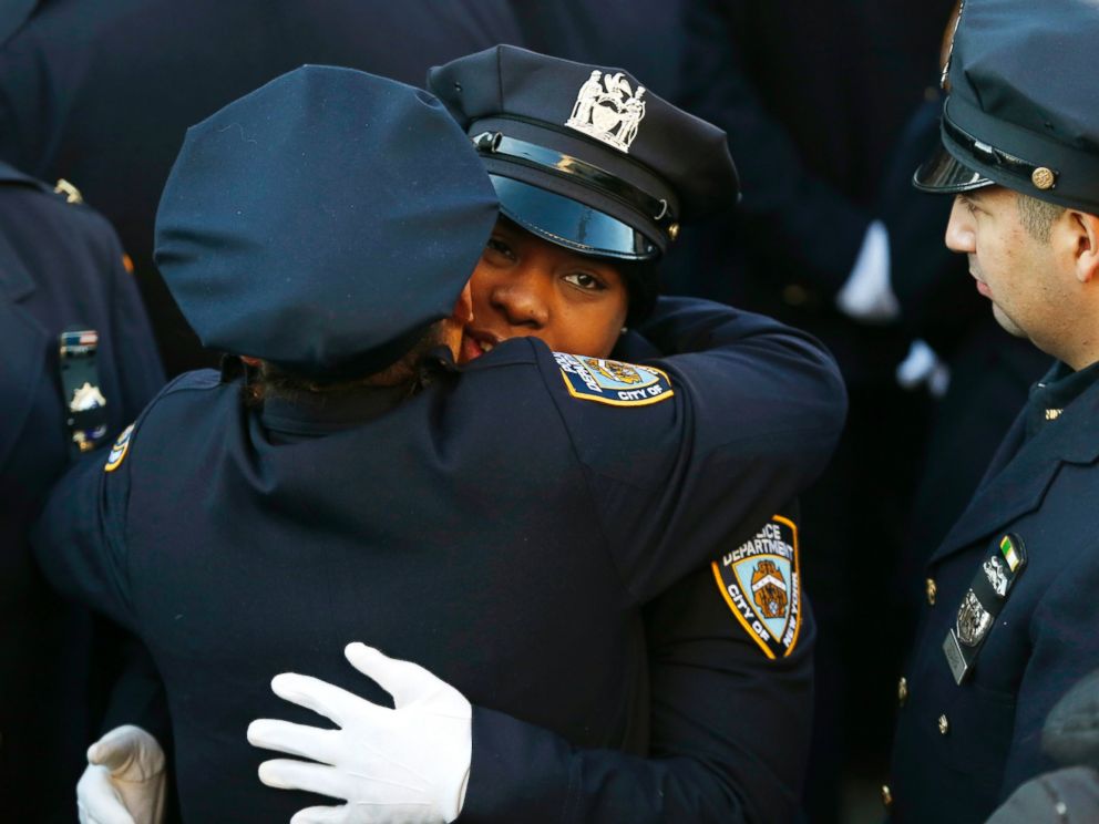 PHOTO: New York City police officers embrace outside of Christ Tabernacle Church, in the Glendale section of Queens, before funeral services for officer Rafael Ramos, Saturday, Dec. 27, 2014, in New York.
