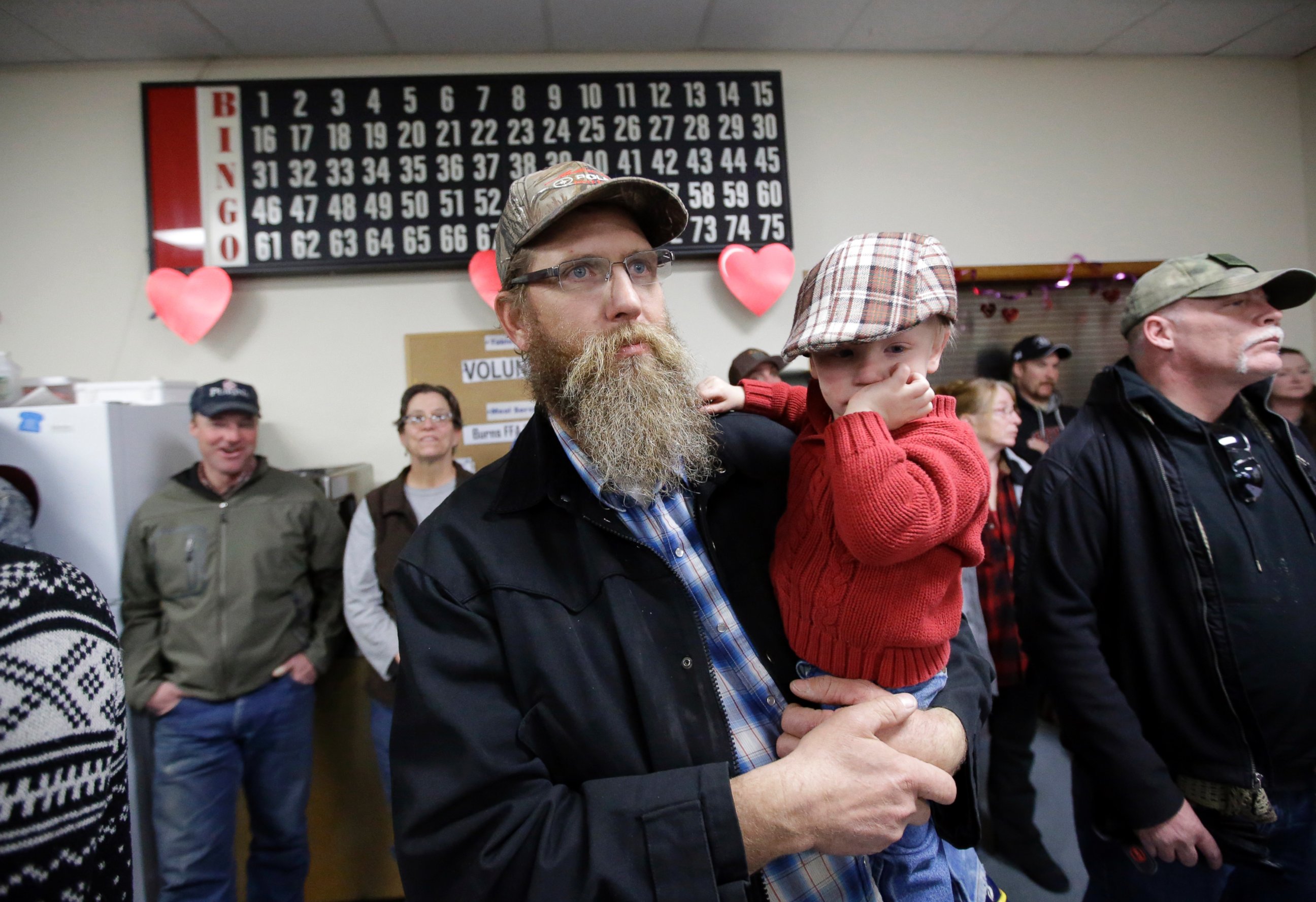 PHOTO: Tom Schaefer holds his son Isaac, while looking on during the Harney County committee of safety town hall called to discuss the occupation of the Malheur National Wildlife Refuge Friday, Jan. 8, 2016, in Burns, Ore.