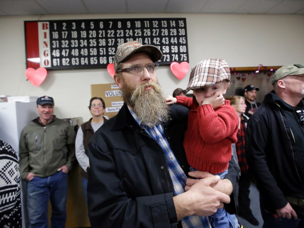 PHOTO: Tom Schaefer holds his son Isaac, while looking on during the Harney County committee of safety town hall called to discuss the occupation of the Malheur National Wildlife Refuge Friday, Jan. 8, 2016, in Burns, Ore.