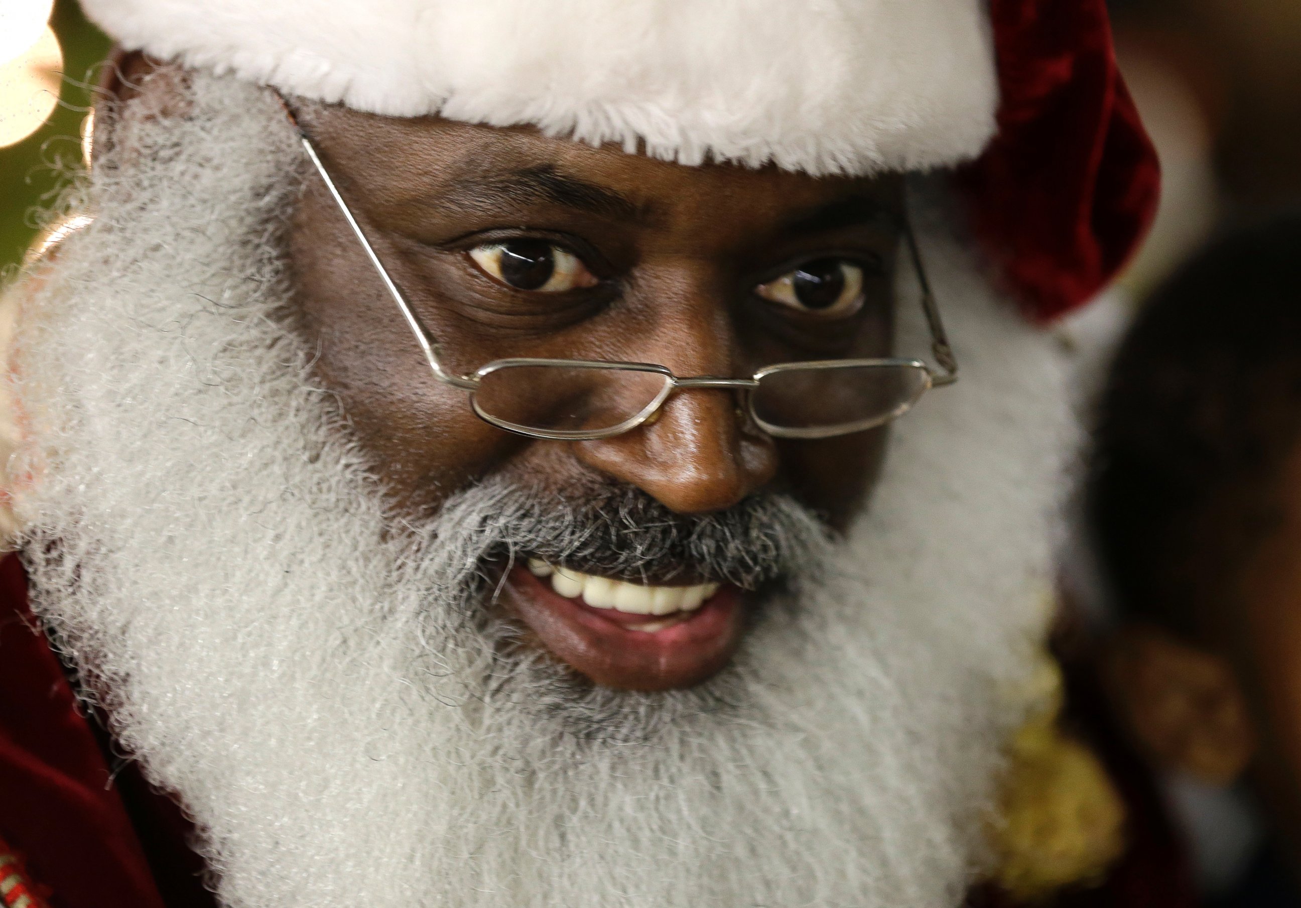 PHOTO: In this Dec. 17, 2013 photo, Dee Sinclair, portraying Santa Claus, reads a story to children in Atlanta. "Kids don't see color. They see a fat guy in a red suit giving toys," says Sinclair.