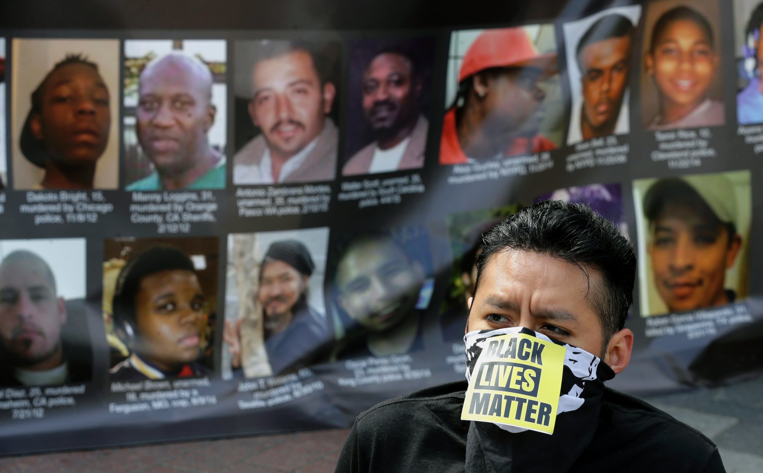 PHOTO: Hugo Diaz wears sits in front of a poster of photos of people who have been shot by law enforcement officers while taking part in a protest against recent shootings of unarmed civilians by police, Tuesday, April 14, 2015, in Seattle. 
