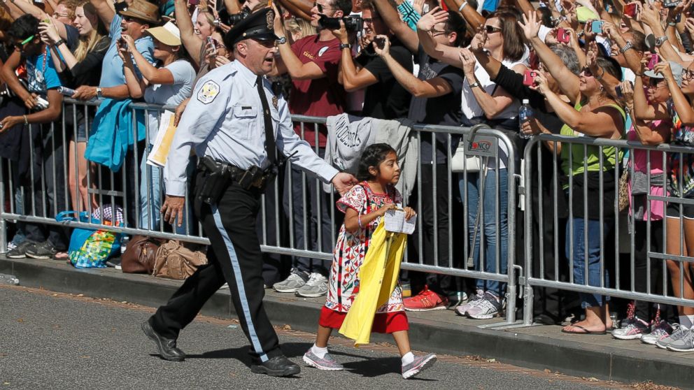 PHOTO: A child is escorted by police during a parade for Pope Francis in Washington, Sept. 23, 2015.