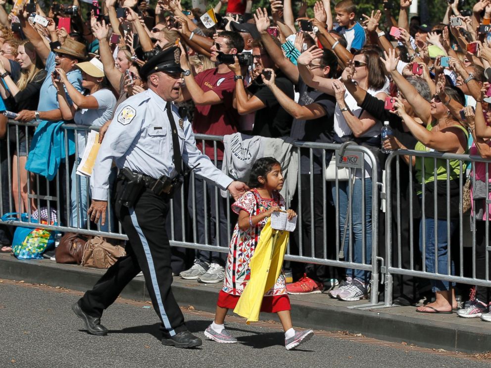 PHOTO: A child is escorted by police during a parade for Pope Francis in Washington, Sept. 23, 2015.