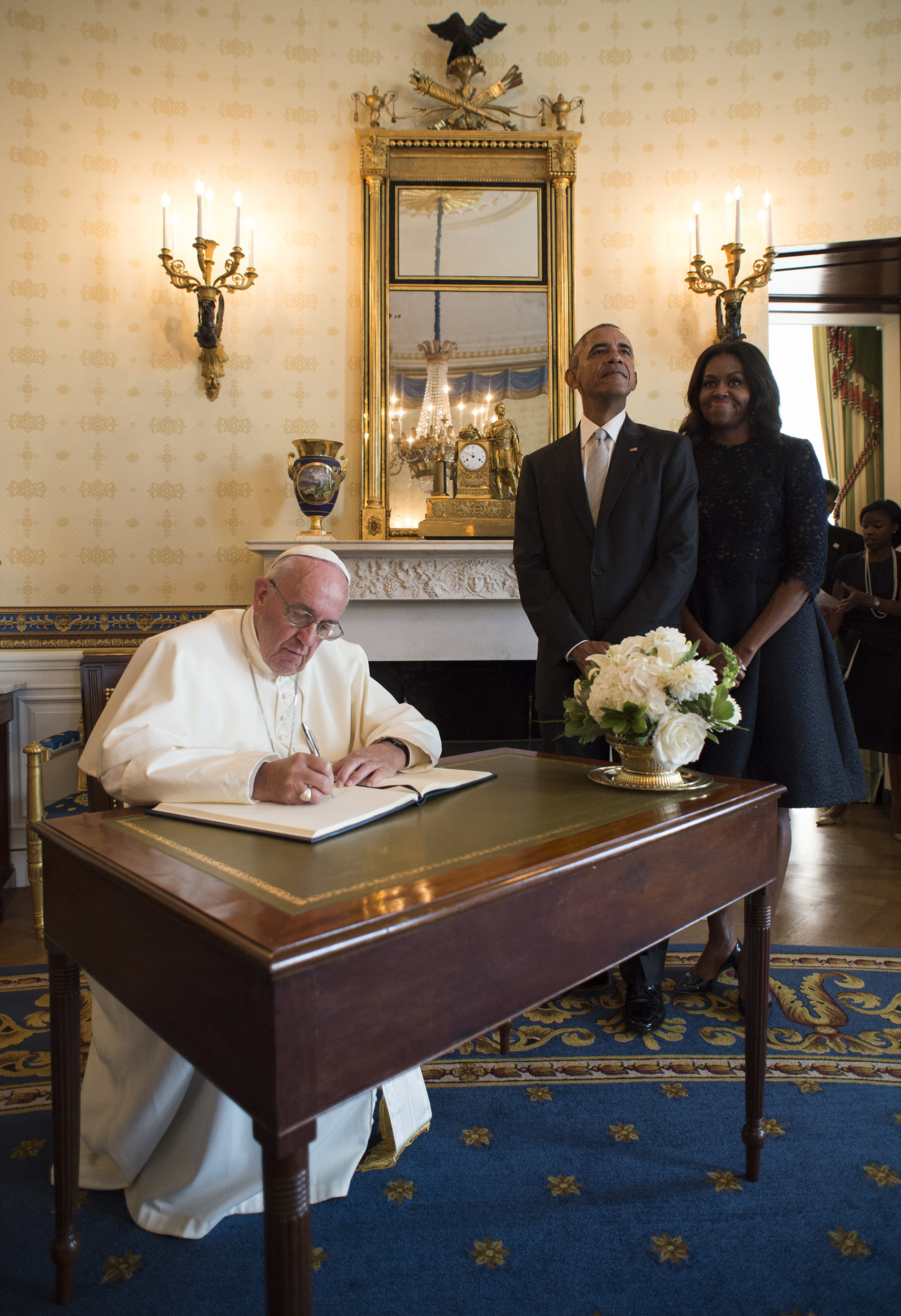 PHOTO: In this photo provided by L'Osservatore Romano, Pope Francis signs a book as first lady Michelle Obama and President Barack Obama look on at the White House in Washington, Sept. 23, 2015.