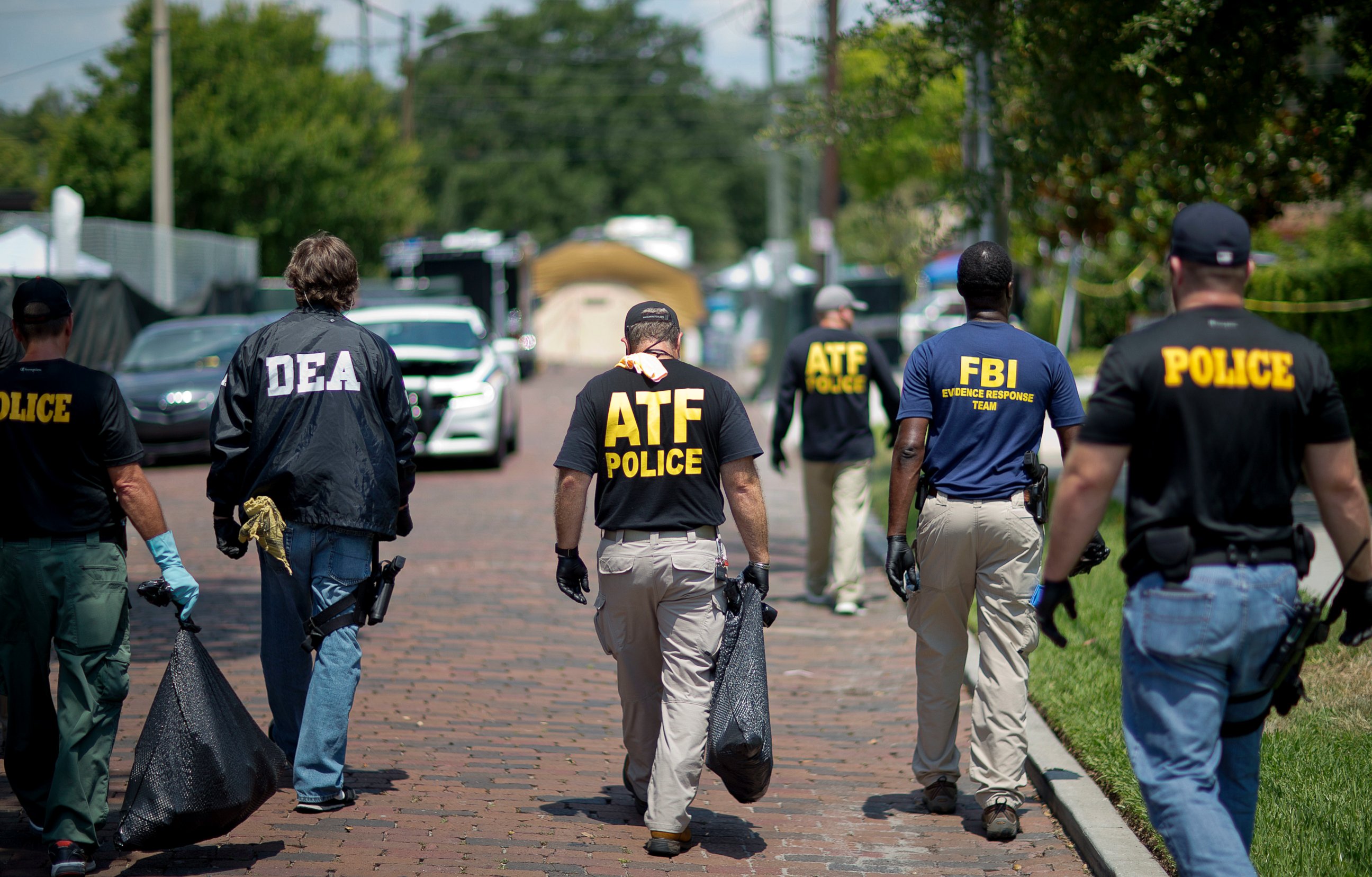 PHOTO: Federal and local law enforcement officials walk through the street next to the scene of a mass shooting at a nightclub, June 13, 2016, in Orlando, Fla.