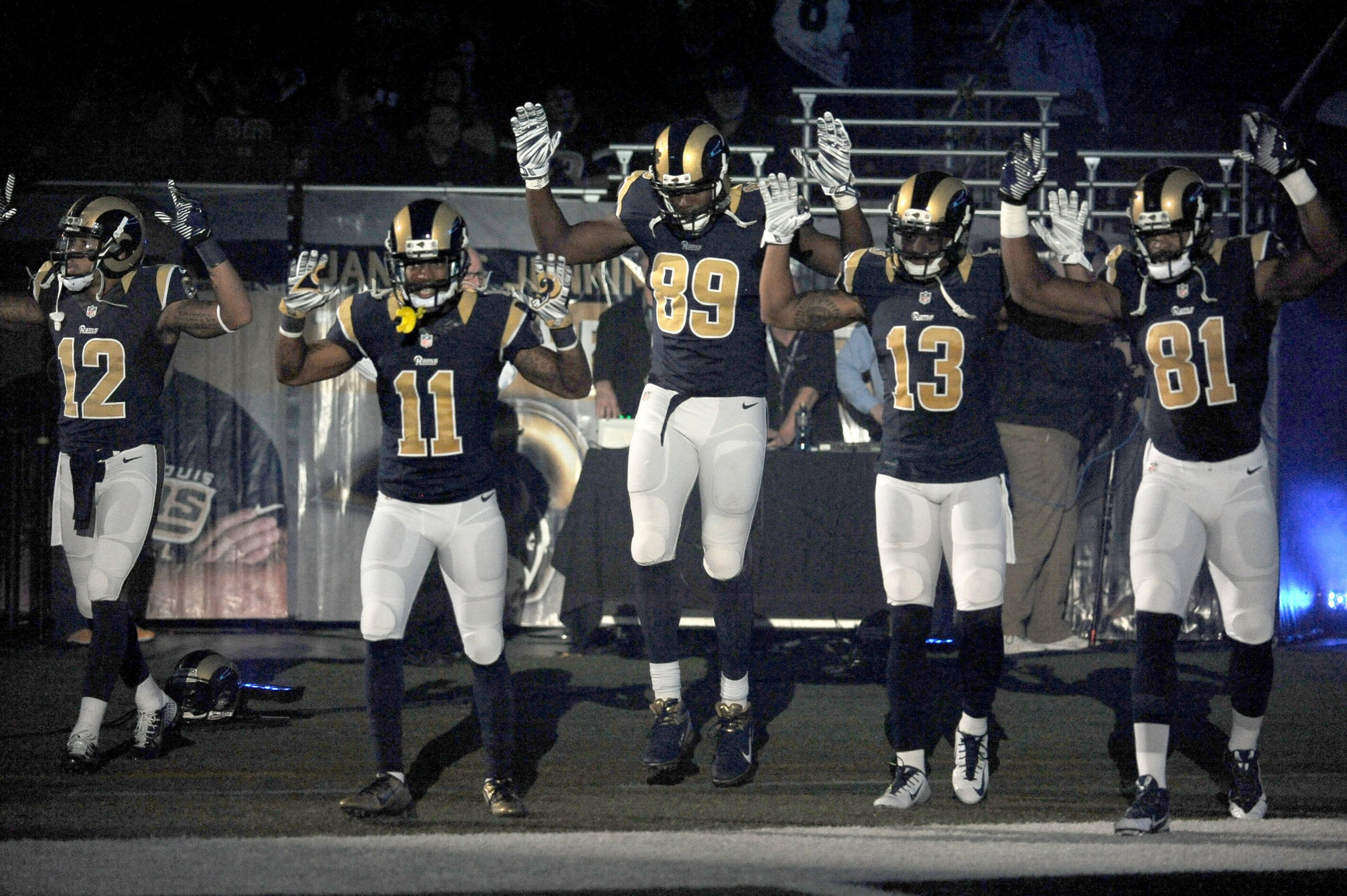 PHOTO: In this Sunday Nov. 30, 2014, file photo, St. Louis Rams players raise their arms in awareness of the events in Ferguson, Mo., as they walk onto the field during introductions before an NFL football game against the Oakland Raiders in St. Louis. 
