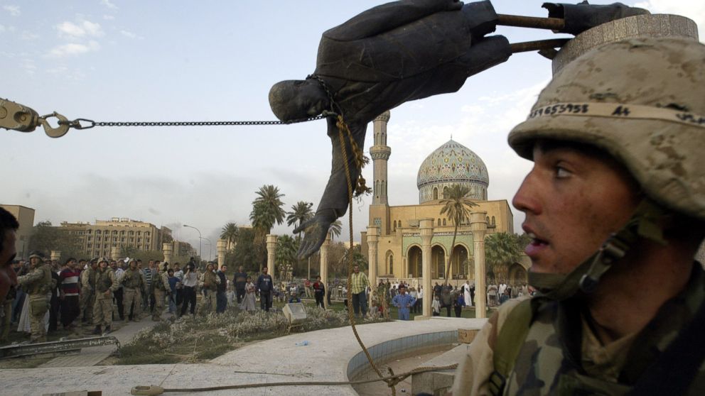 The April 9, 2003 file photo shows Iraqi civilians and U.S. soldiers pulling down a statue of Saddam Hussein in downtown Baghdad.
