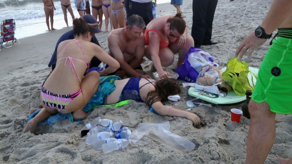 PHOTO: Emergency responders assist a teenage girl at the scene of a shark attack in Oak Island, N.C., Sunday, June 14, 2015.