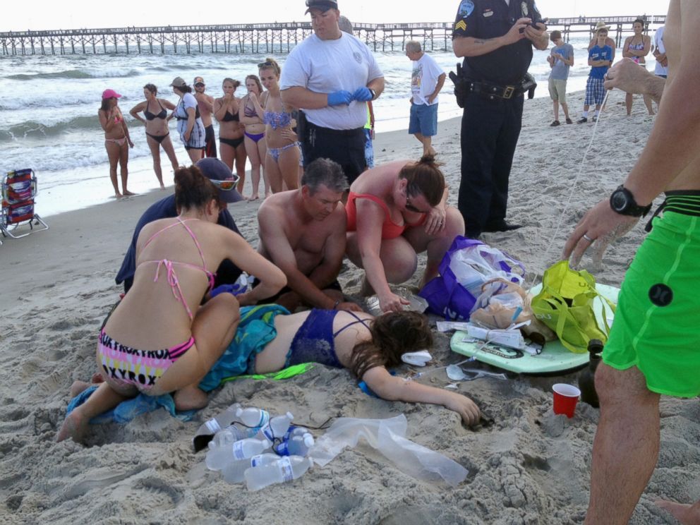 PHOTO: Emergency responders assist a teenage girl at the scene of a shark attack in Oak Island, N.C., Sunday, June 14, 2015.