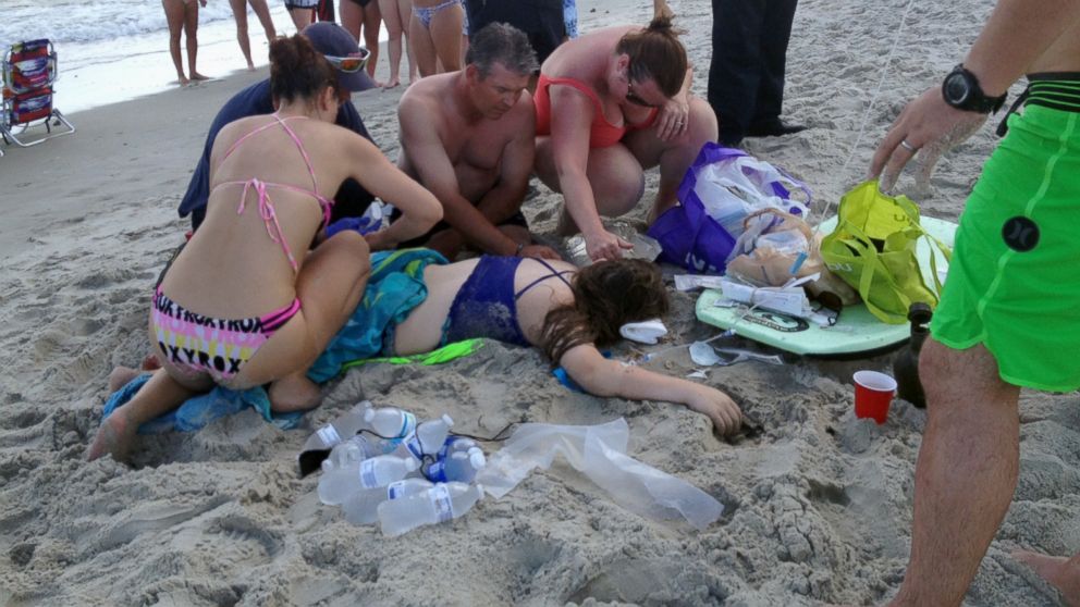 Emergency responders assist a teenage girl at the scene of a shark attack in Oak Island, N.C., June 14, 2015. Mayor Betty Wallace of Oak Island, a seaside town bordered to the south by the Atlantic Ocean, said that hours after the teenage girl suffered severe injuries in a shark attack Sunday a teenage boy was also severely injured. 
