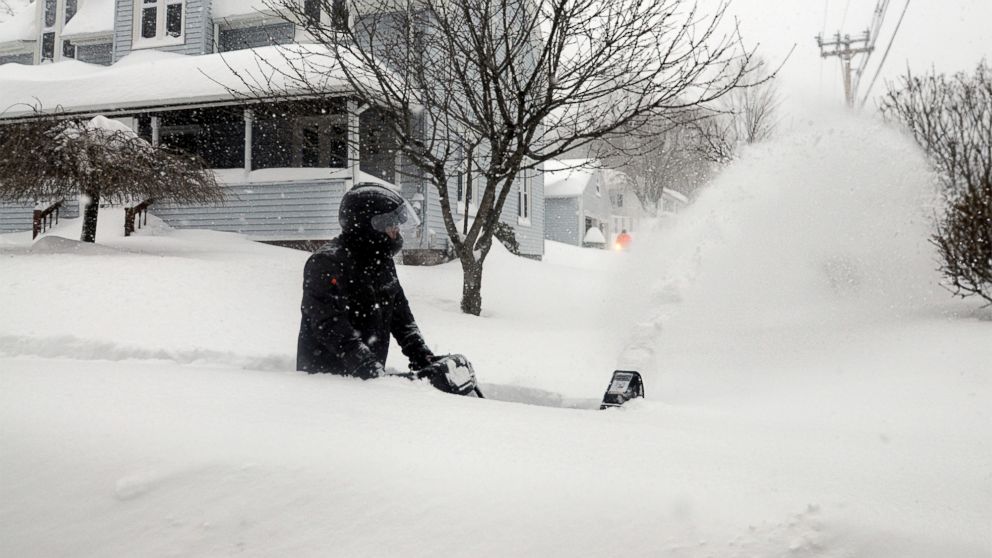 PHOTO: John Slasell wades through waist-deep snow as he snow blows the sidewalk along Slater St. in Webster, Mass. 