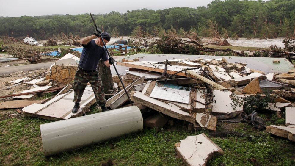 PHOTO: Kevin Calaway pries apart debris from a cabin shattered from a flood at a resort along the Blanco River, May 26, 2015, in Wimberley, Texas.