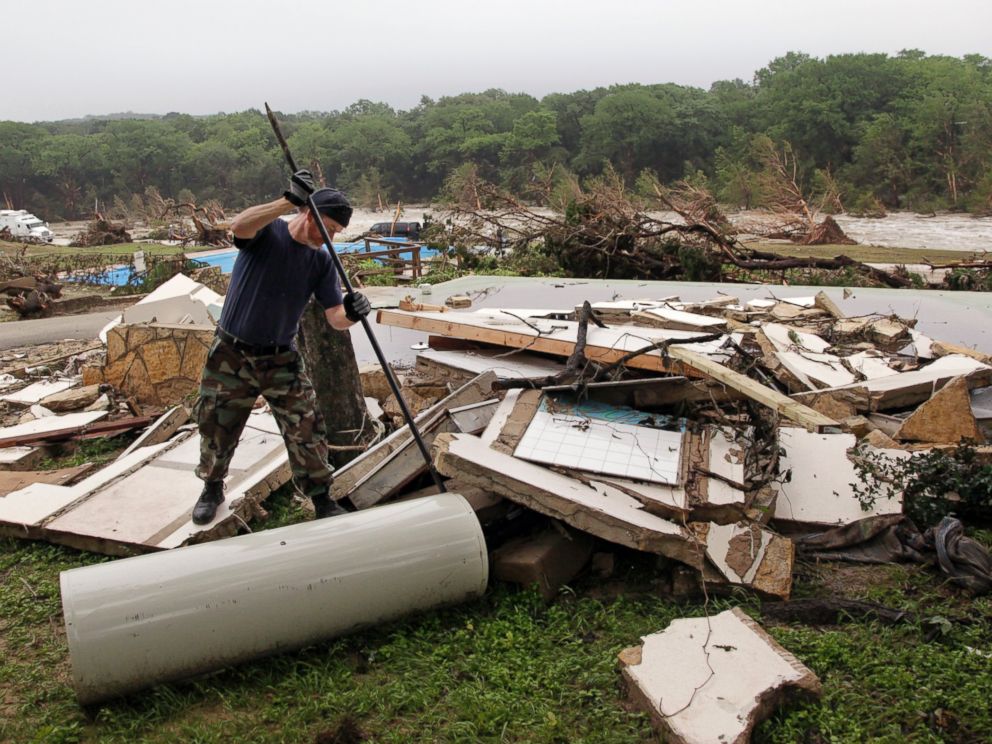 PHOTO: Kevin Calaway pries apart debris from a cabin shattered from a flood at a resort along the Blanco River, May 26, 2015, in Wimberley, Texas.