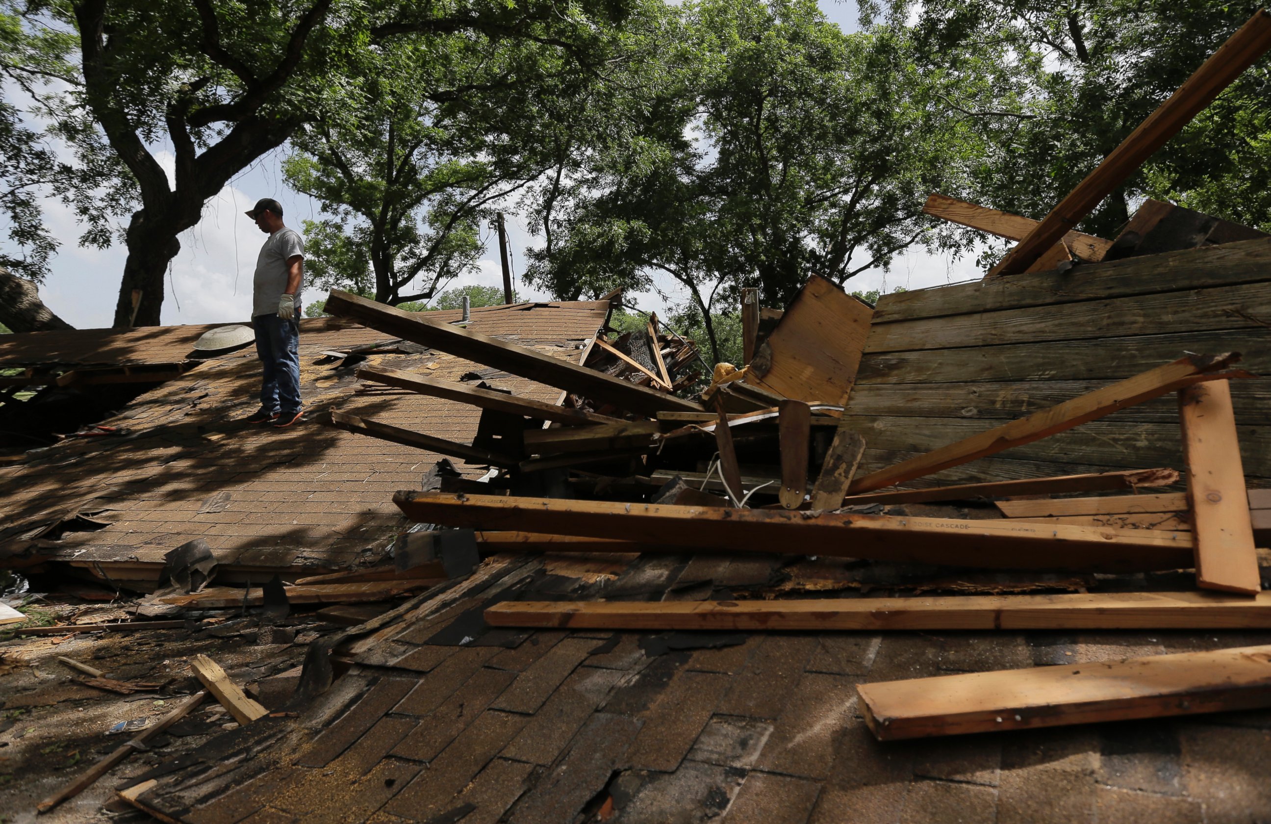 PHOTO: A man looks through debris at a home recently destroyed by flood waters along the Blanco River, May 26, 2015, in Wimberley, Texas.