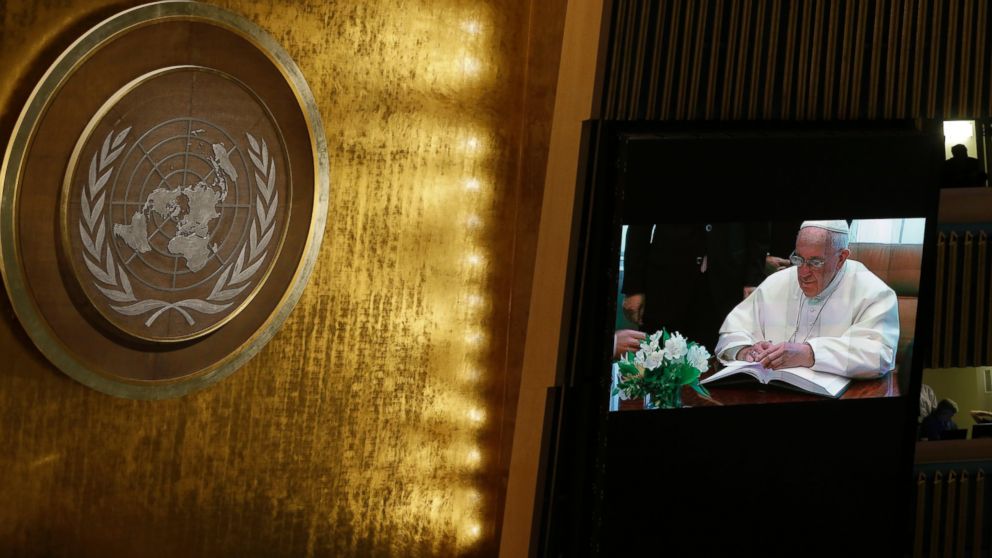 Pope Francis is seen on a video monitor as he signs the United Nations guest book before addressing the General Assembly, Sept. 25, 2015 at United Nations headquarters.  