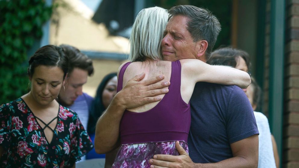 PHOTO: Don Damond, the fiance of Justine Damond, is comforted outside his home as demonstrators march by during the Peace and Justice March for Justine Thursday, July 20, 2017, in Minneapolis.