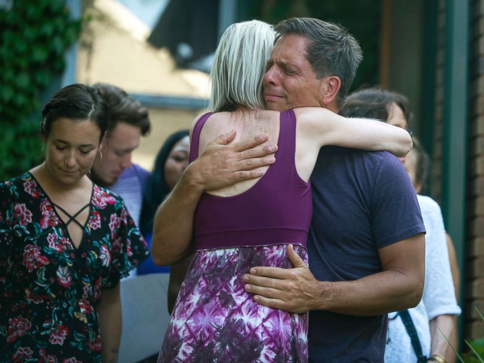 PHOTO: Don Damond, the fiance of Justine Damond, is comforted outside his home as demonstrators march by during the Peace and Justice March for Justine Thursday, July 20, 2017, in Minneapolis.