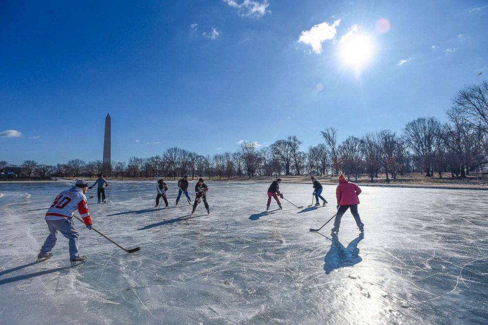 PHOTO: People play ice hockey on a frozen lake near the Washington Monument, in Washington, DC on January 6, 2018.
