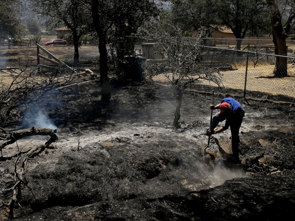 PHOTO: Alan Germain puts out hotspots on his neighbors property destroyed by a wildfire, June 24, 2016, near Lake Isabella, Calif.