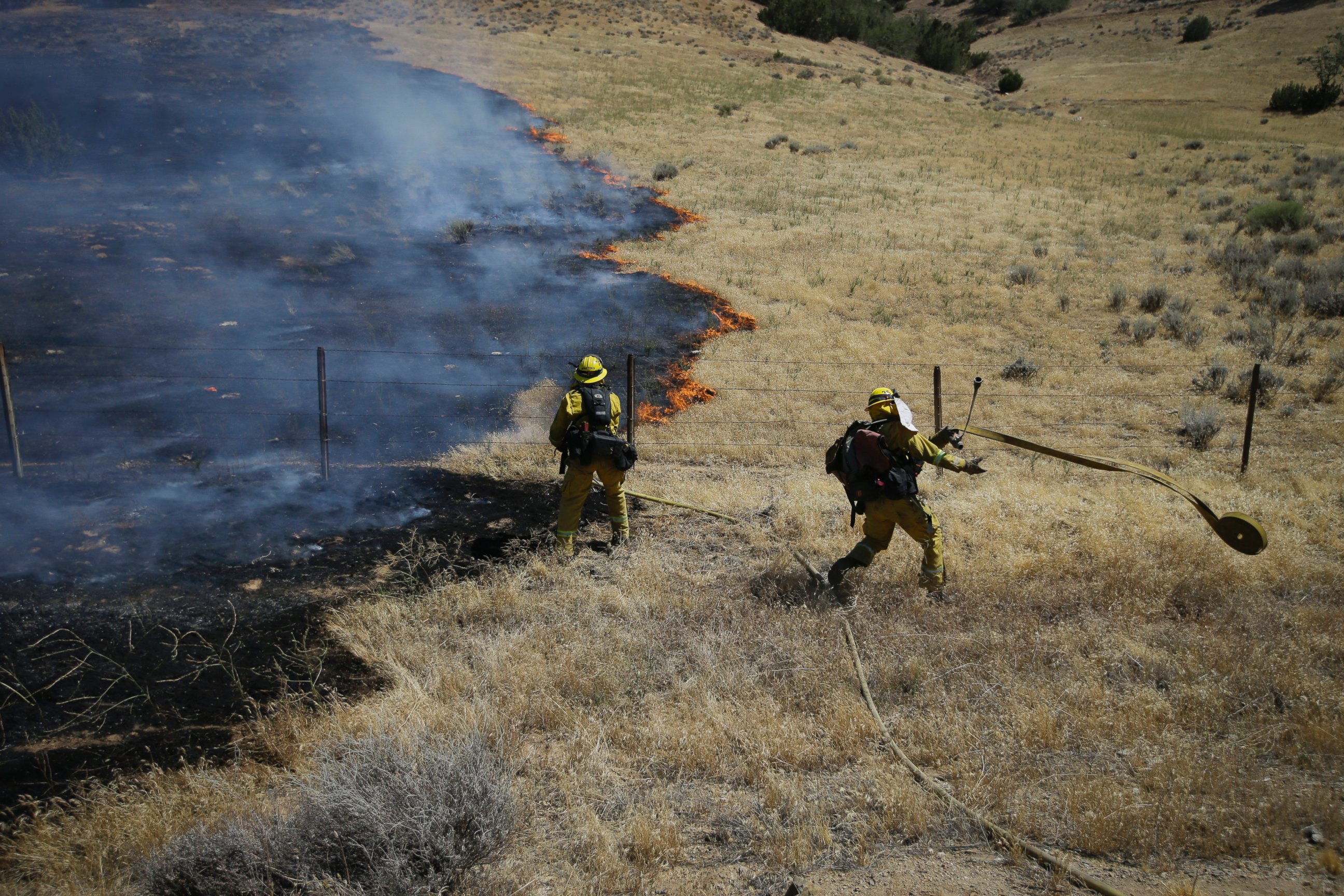 PHOTO: Firefighters prepare water hoses to battle a wildfire burning along Highway 178 near Lake Isabella, Calif., June 24, 2016.