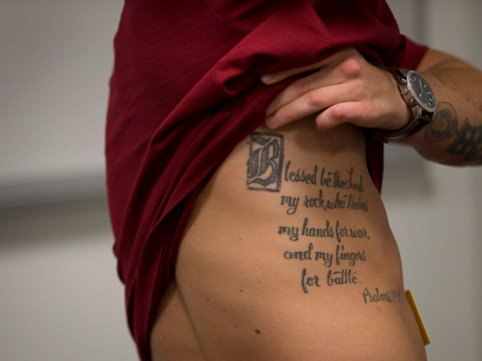 PHOTO: This photo taken May 13, 2014 shows medically retired Marine Lance Cpl. Kyle Carpenter lifting his shirt to show a tattoo on his side as he speaks with media at the Pentagon.