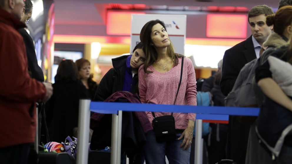 Karen Barker and her daughter Grace Barker wait in line to see if they will be able to board a rescheduled flight to Texas at LaGuardia Airport in New York, on Jan. 26, 2015.