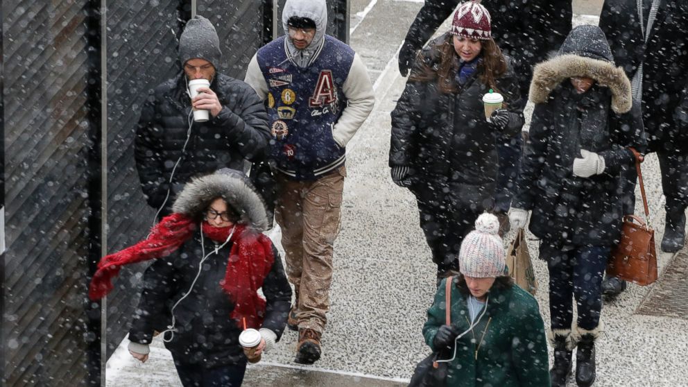 PHOTO: A light snow falls on pedestrians in New York, Jan. 26, 2015. 