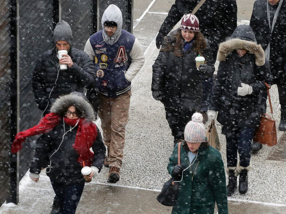 PHOTO: A light snow falls on pedestrians in New York, Jan. 26, 2015.