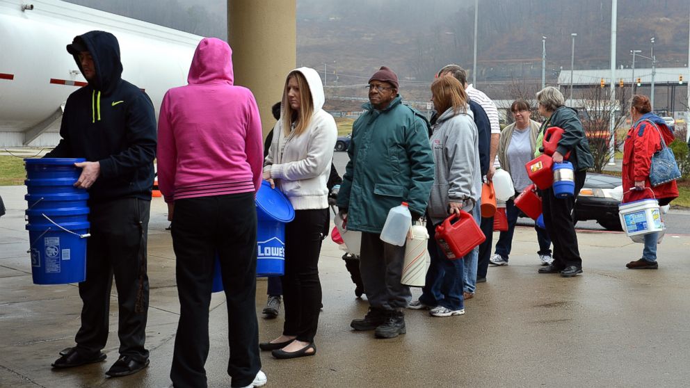 PHOTO: People wait in line for water from a 7500 gallon tanker truck brought in from Washington, Pa., on Jan. 10, 2014, at Riverside High School near Charleston, W.Va. 