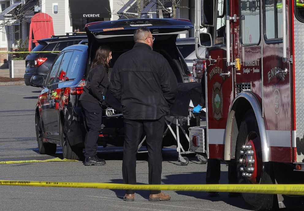 PHOTO: Officials from the medical examiner's office take away a body as emergency services personnel attend the scene after a vehicle crashed into an Apple store in Hingham, Mass., Nov.  21, 2022. 