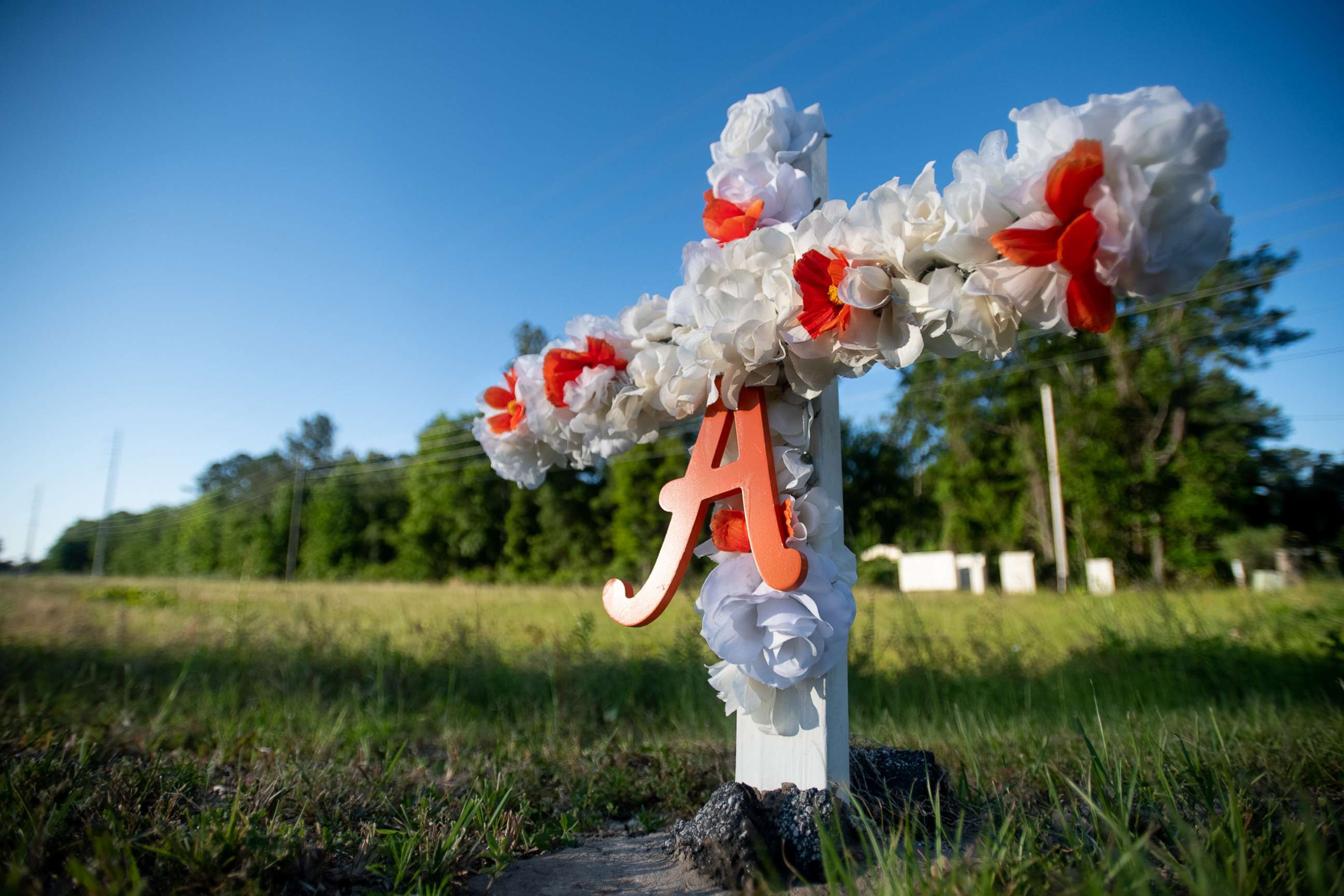 PHOTO: A cross with flowers and the letter A sits at the entrance to the Satilla Shores neighborhood where Ahmaud Arbery was shot and killed, May 7, 2020 in Brunswick, Ga.