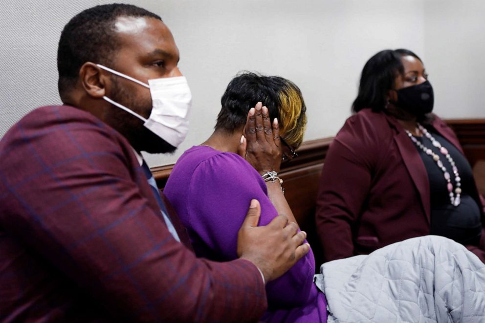 PHOTO: Attorney Lee Merritt consoles Wanda Cooper-Jones, mother of Ahmaud Arbery, after seeing photos of her son on a monitor, during the trial of William "Roddie" Bryan, Travis McMichael and Gregory McMichael, in Brunswick, Ga., Nov. 23, 2021.
