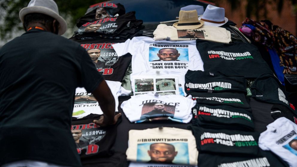 PHOTO: A man organizes t-shirts memorializing George Floyd and Ahmaud Arbery outside the Glynn County Courthouse where Gregory and Travis McMichael attended a preliminary hearing on June 4, 2020 in Brunswick, Ga.