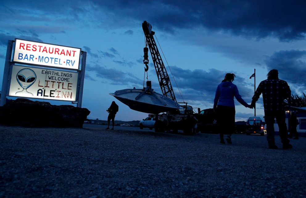 PHOTO: People walk near the Little A'Le'Inn during an event inspired by the "Storm Area 51" internet hoax, Thursday, Sept. 19, 2019, in Rachel, Nev.