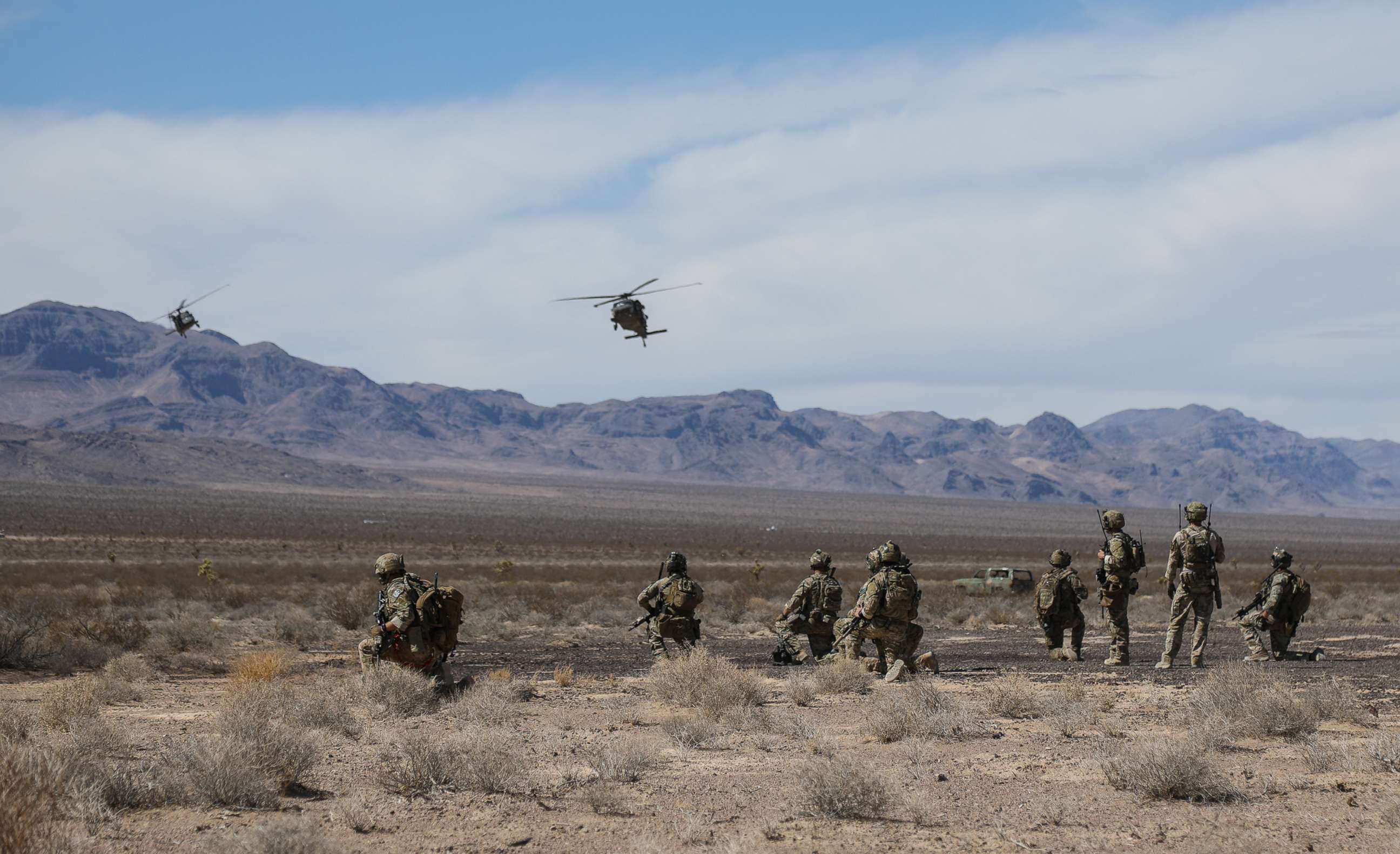 PHOTO: U.S. Special Forces Soldiers and Airmen from the 99th Civil Engineer Squadron EOD team and 66th Rescue Squadron, watch as two UH-60 Blackhawk helicopters land at the Nevada Test and Training Range near Nellis AFB, Nevada, Aug. 28, 2018.